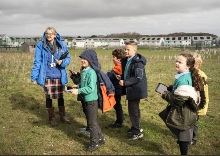 Eco Lead with children outside using iPads at Sky Primary and Eden Project Nursery