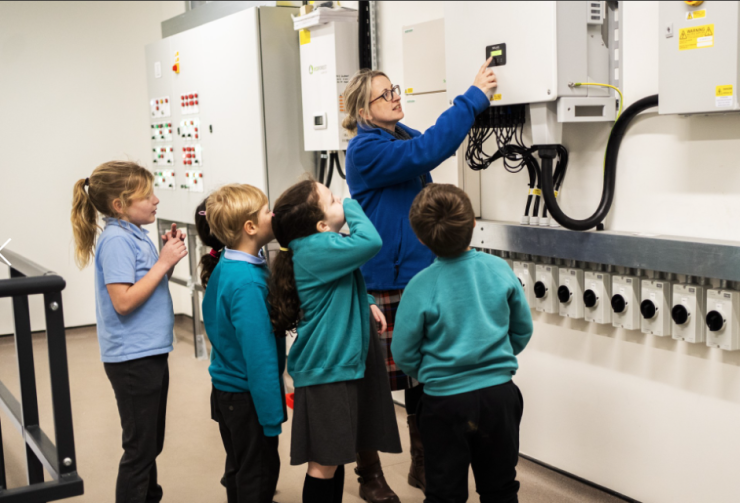 Teacher showing children the renewable energy data dashboard
